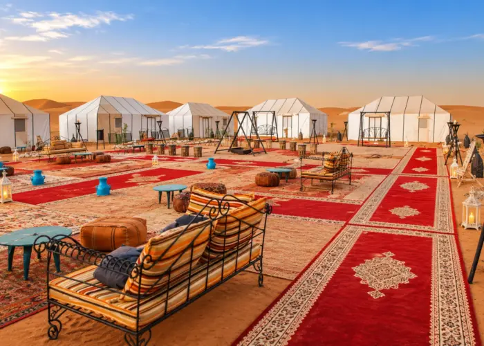 Luxury desert camp in Merzouga with neatly arranged red Moroccan rugs