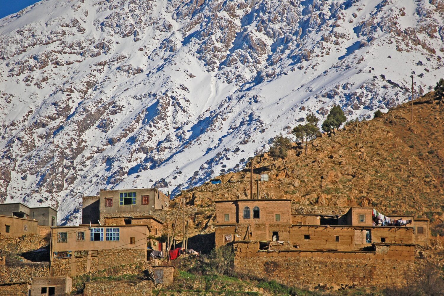 Traditional Berber village with snow-covered Atlas Mountains in Morocco