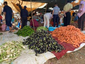 Berber weekly market in the High Atlas Mountains with locals selling fresh produce and traditional goods.