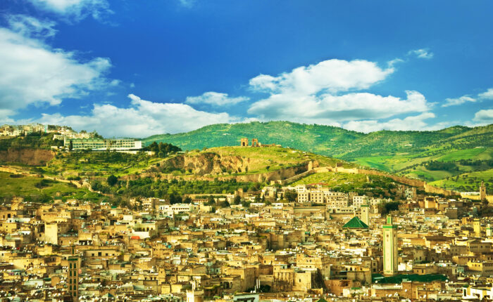 Panoramic view of Fes, Morocco with the historic medina, city walls, and green hills