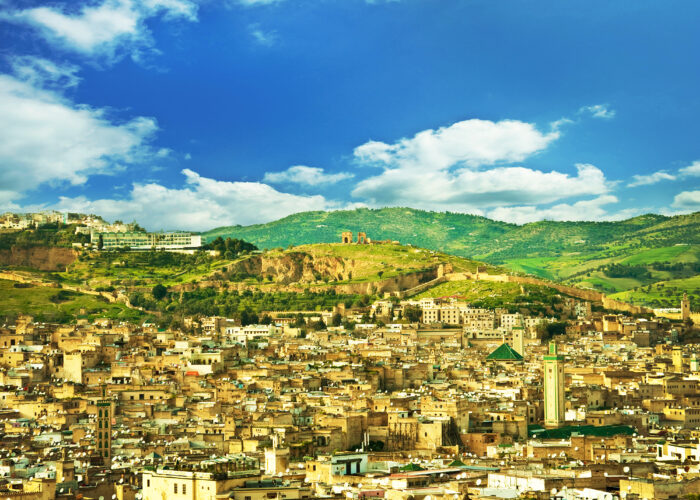 Panoramic view of Fes, Morocco with the historic medina, city walls, and green hills