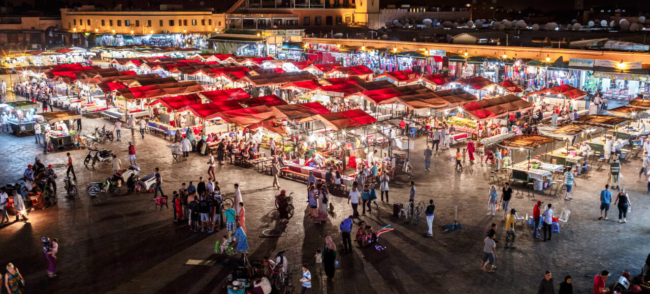 Jemaa el Fna square in Marrakech at night with food stalls and Koutoubia Mosque