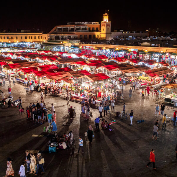 Jemaa el Fna square in Marrakech at night with food stalls and Koutoubia Mosque