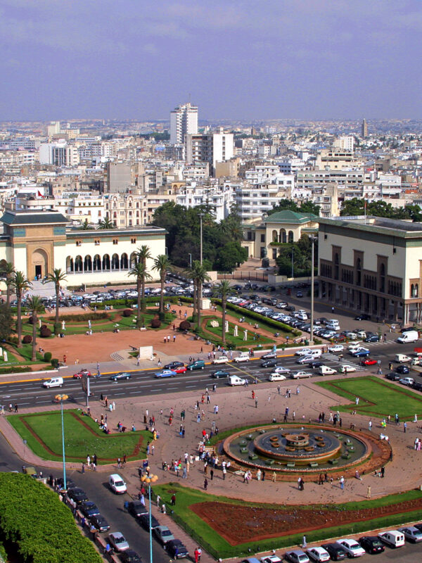 private day trip from Marrakech to Casablanca,. Mohammed V Square in Casablanca with palm trees and historic buildings, Morocco