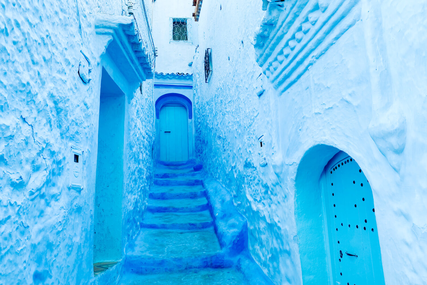 9-Day Imperial Cities & Sahara Tour from Casablanca. Blue-painted alley in Chefchaouen, Morocco, showing traditional Moroccan architecture and peaceful atmosphere