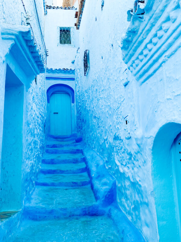 9-Day Imperial Cities & Sahara Tour from Casablanca. Blue-painted alley in Chefchaouen, Morocco, showing traditional Moroccan architecture and peaceful atmosphere