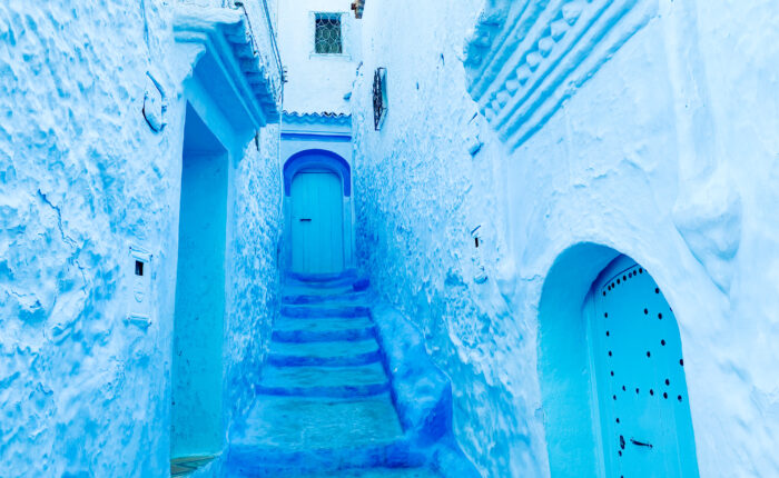 9-Day Imperial Cities & Sahara Tour from Casablanca. Blue-painted alley in Chefchaouen, Morocco, showing traditional Moroccan architecture and peaceful atmosphere