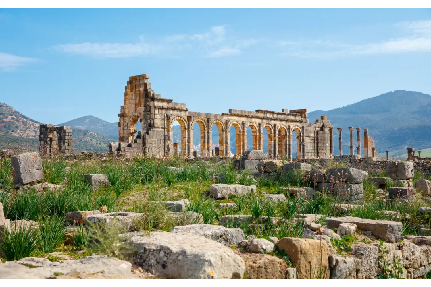 Ancient Roman ruins of Volubilis surrounded by green hills in Morocco
