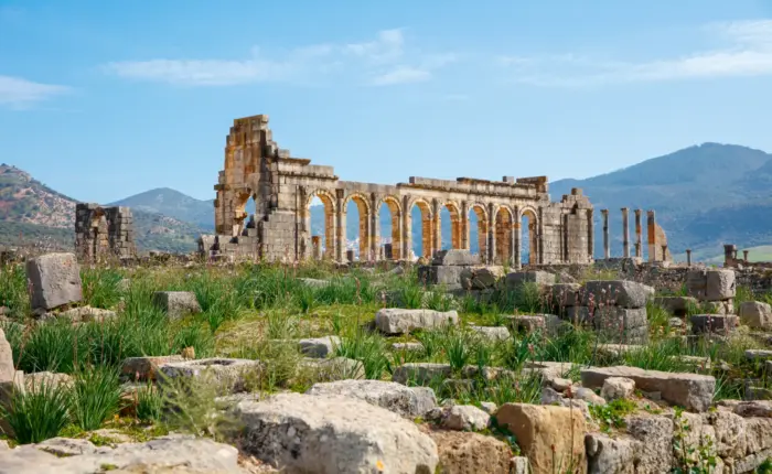 Ancient Roman ruins of Volubilis surrounded by green hills in Morocco