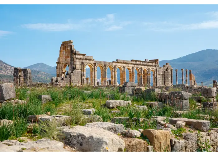 Ancient Roman ruins of Volubilis surrounded by green hills in Morocco