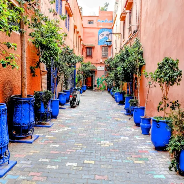 Colorful Marrakech street with blue pots and local shops during Best 9 Day Morocco Tour from Tangier