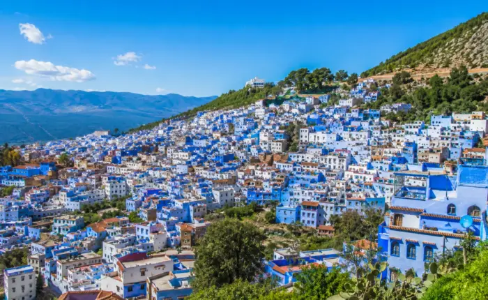 Panoramic view of Chefchaouen's blue-painted houses under a clear sky in the Rif Mountains, Morocco.