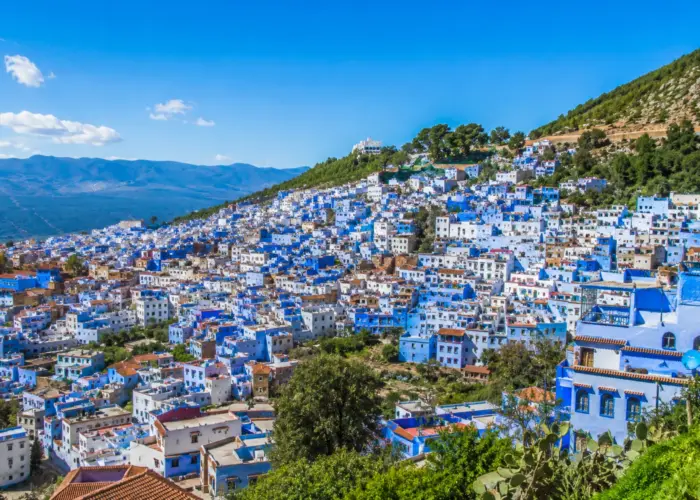 Panoramic view of Chefchaouen's blue-painted houses under a clear sky in the Rif Mountains, Morocco.