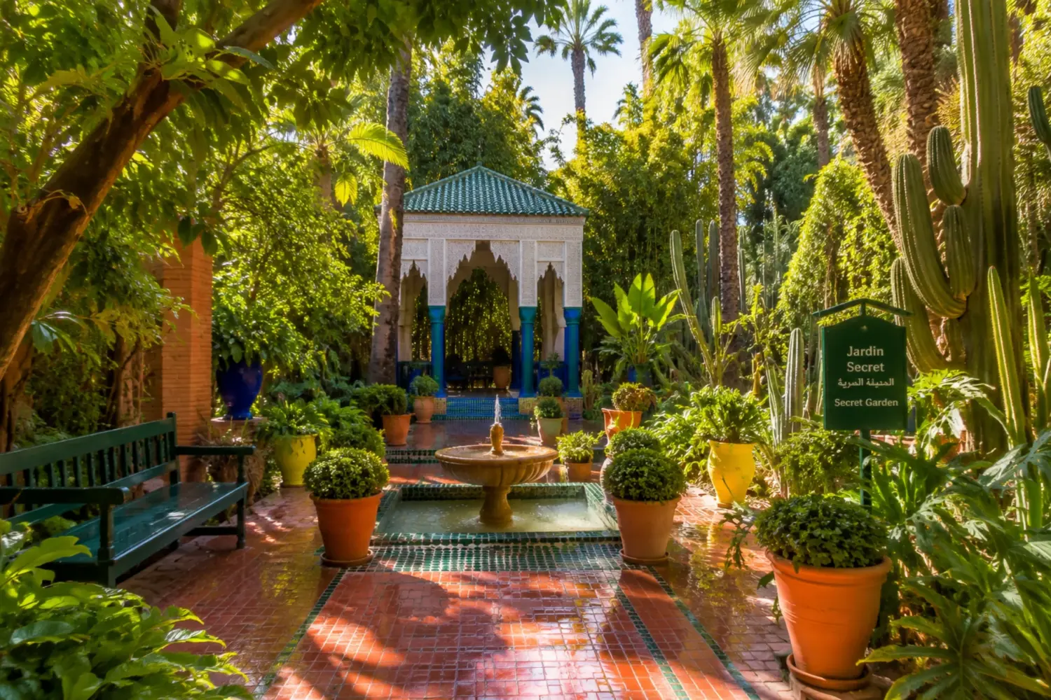 Lush Secret Garden courtyard with fountain and exotic plants in Marrakech .