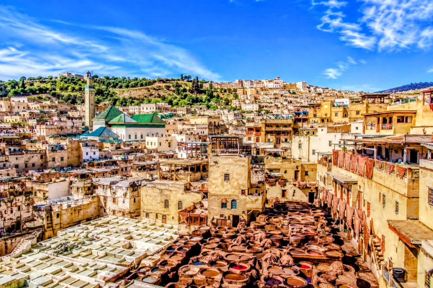 Panoramic view of Fes Medina and traditional leather tanneries under a clear blue sky during
